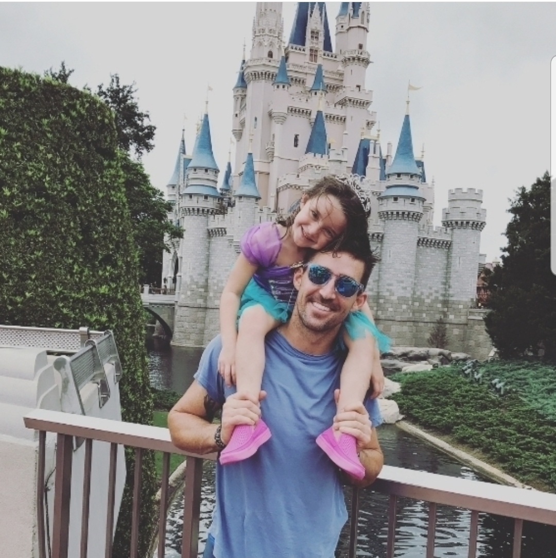 Jake Owen and daughter Paris pose in front of Cinderella's Castle