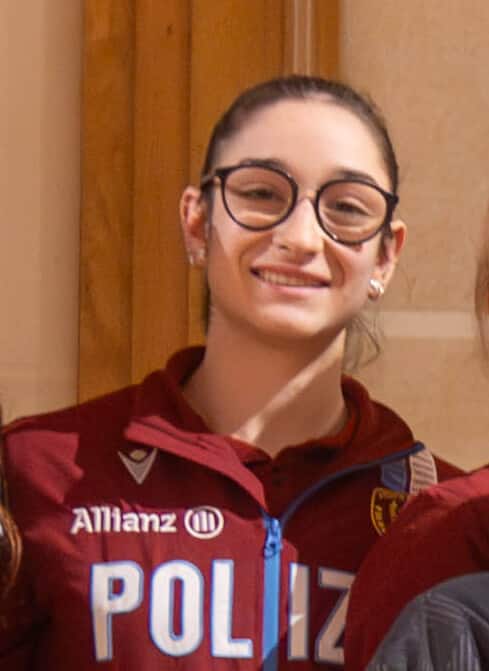 woman with horn rimmed glasses smiling at camera